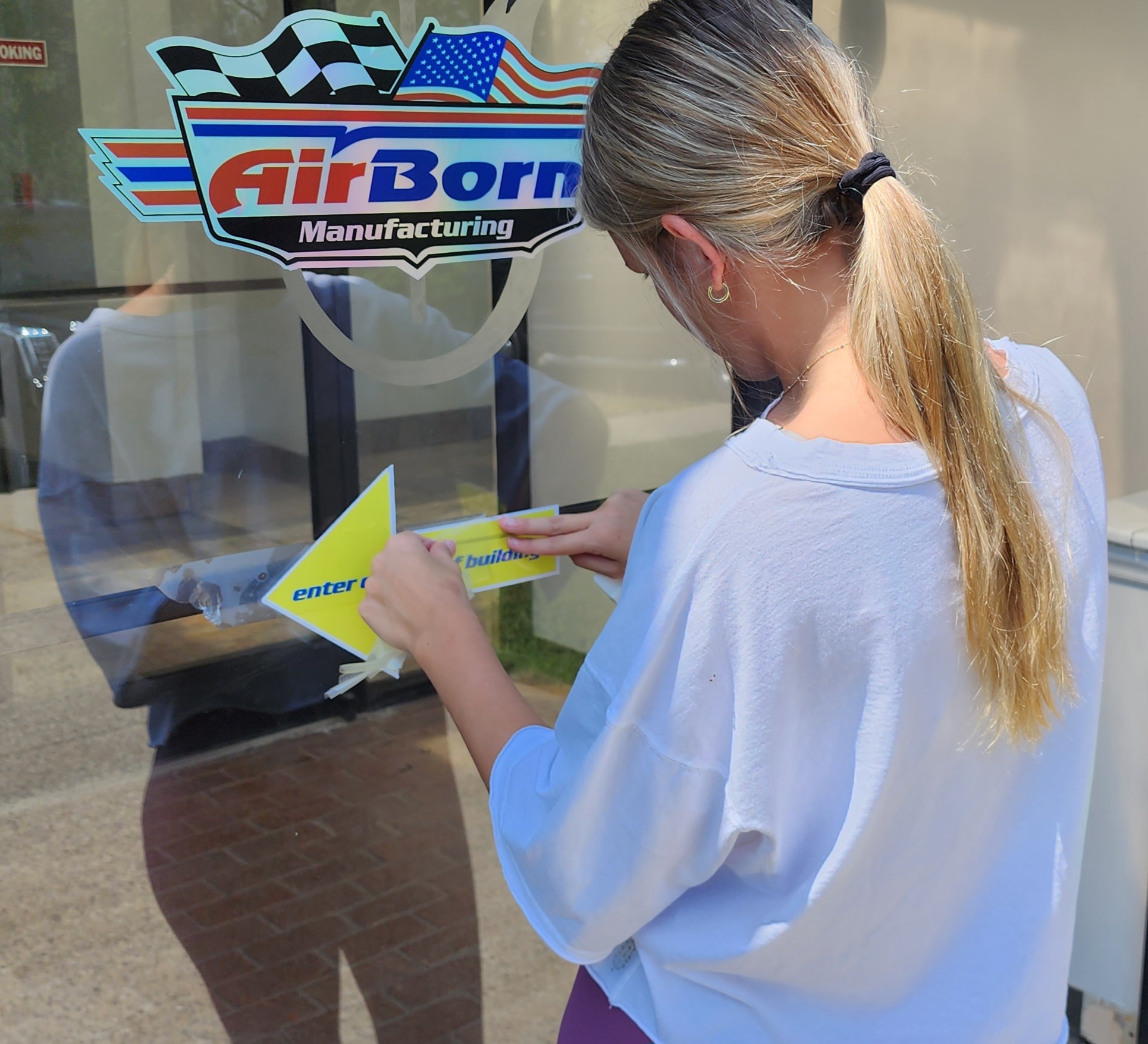 AirBorn Manufacturing shop window branding being applied to glass.