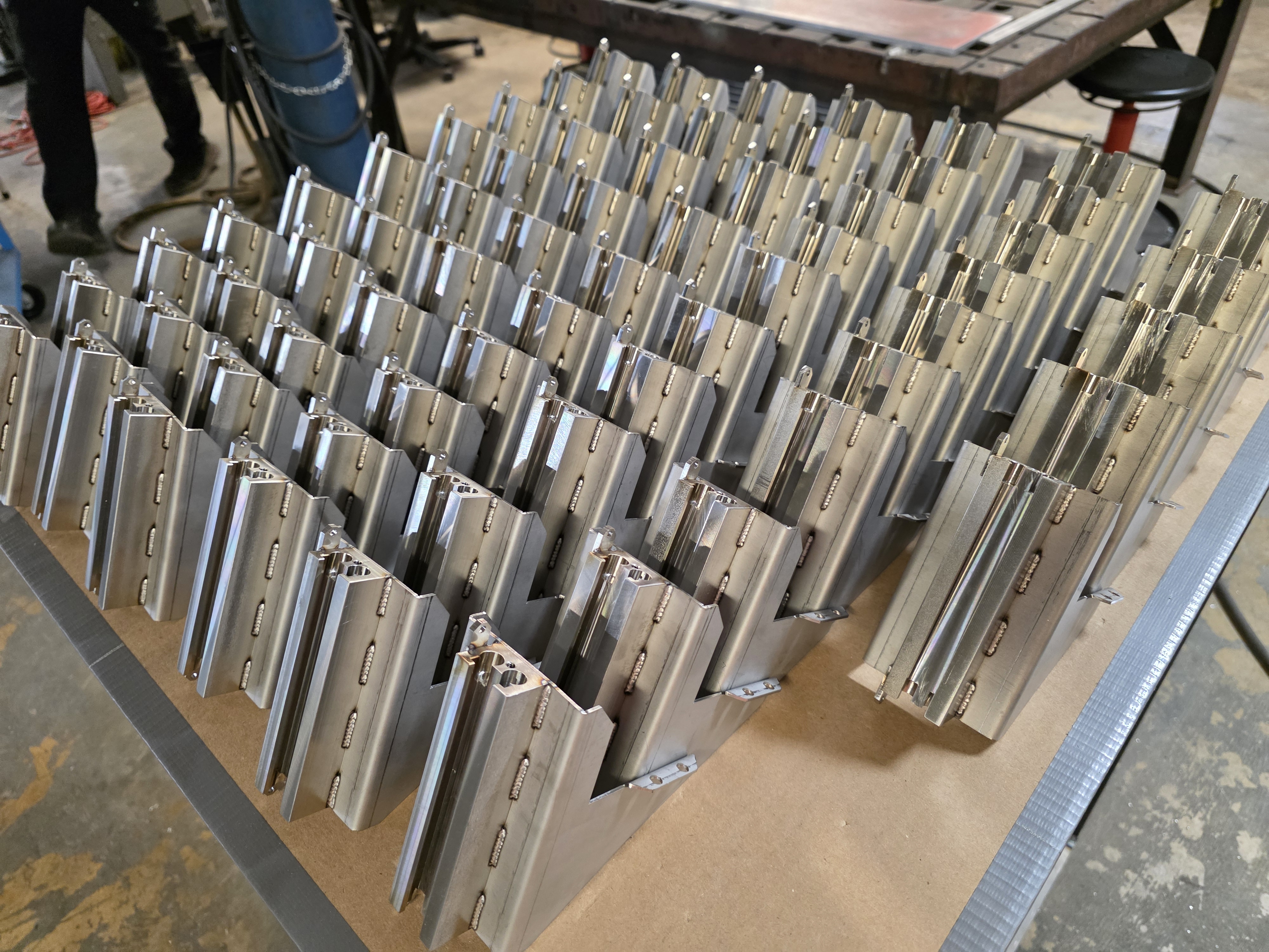 Batch of machined aluminum brackets organized for production assembly.