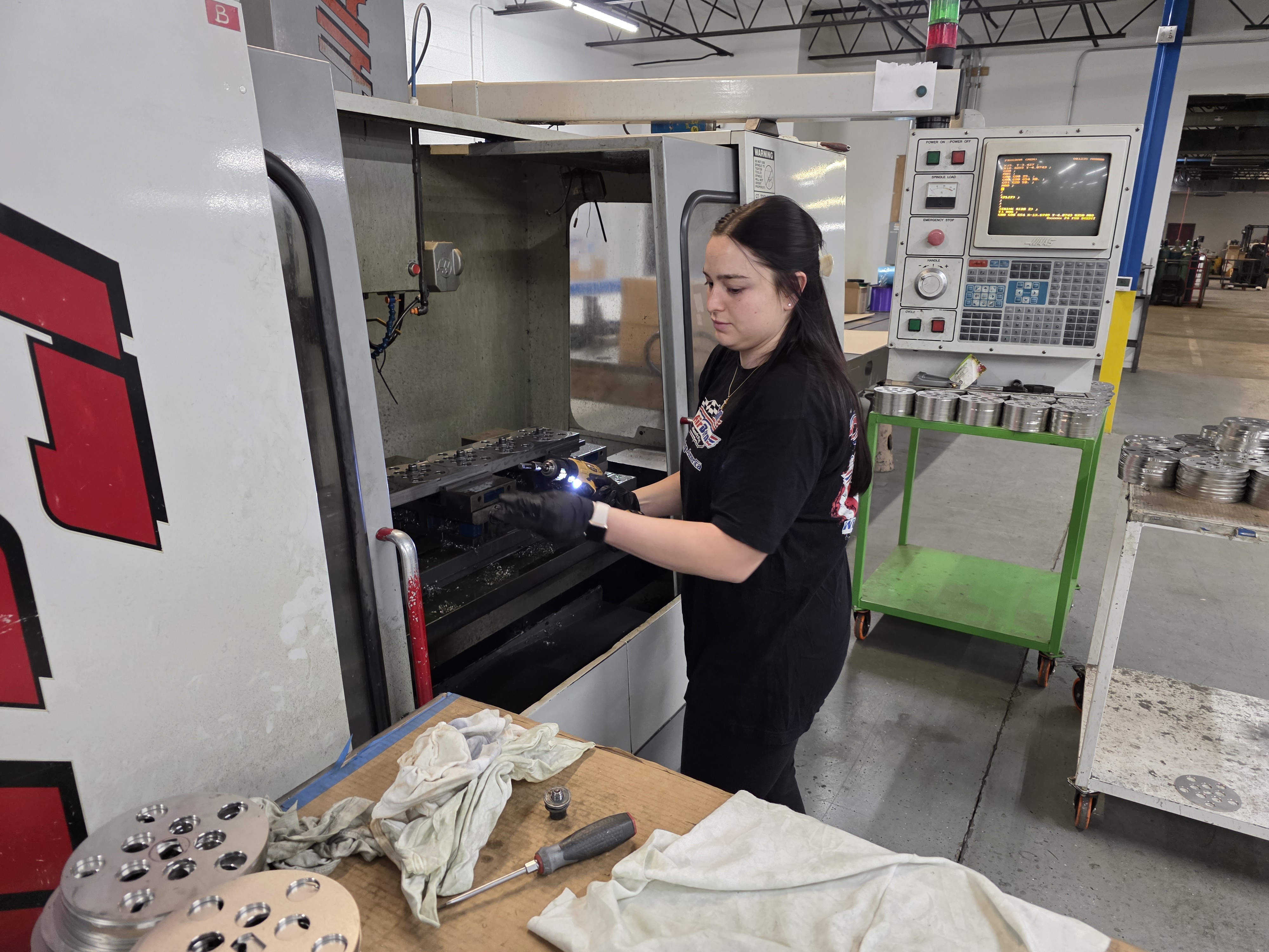 AirBorn Manufacturing team member operating a CNC machining workstation on the shop floor.