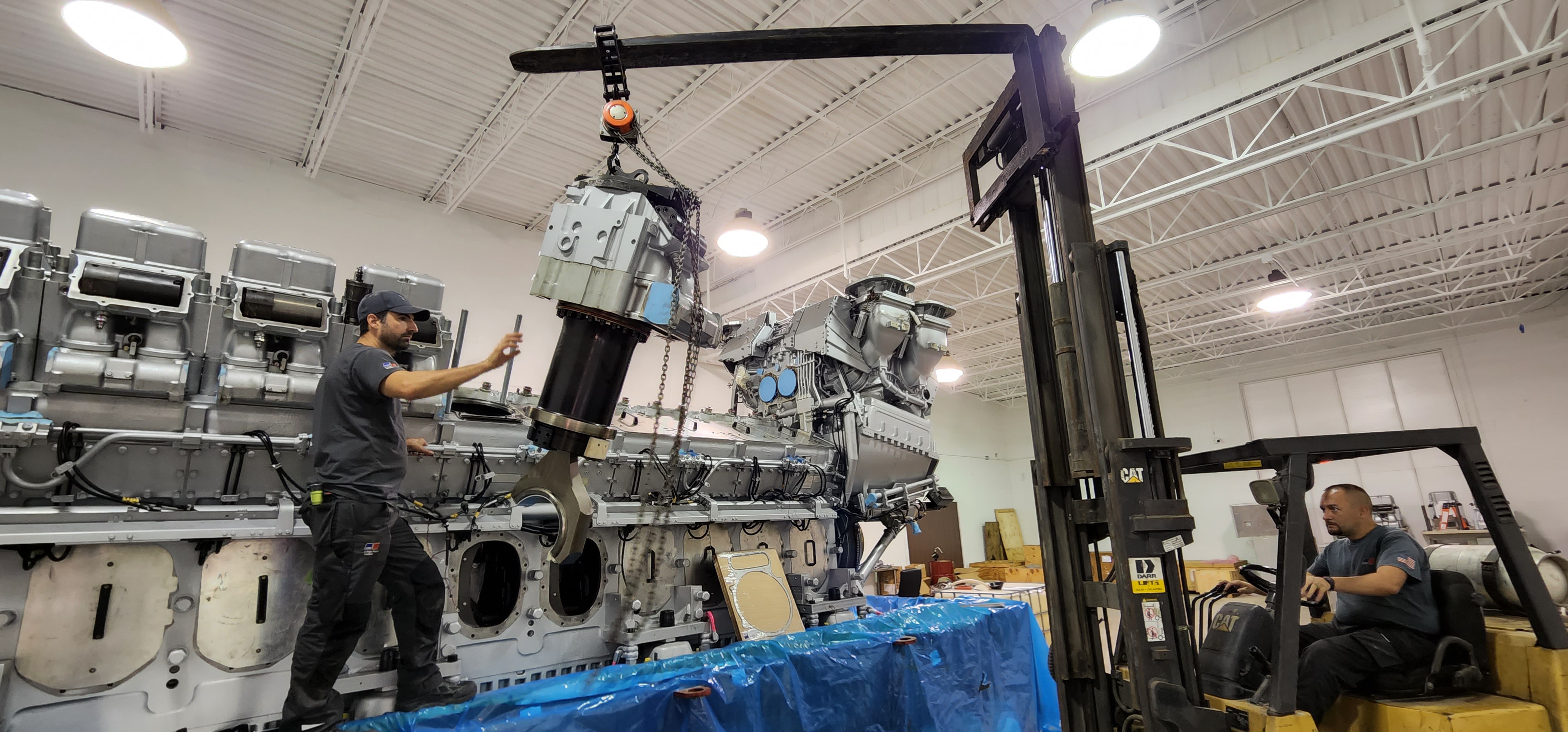 Forklift-assisted installation of a large engine component in the shop.