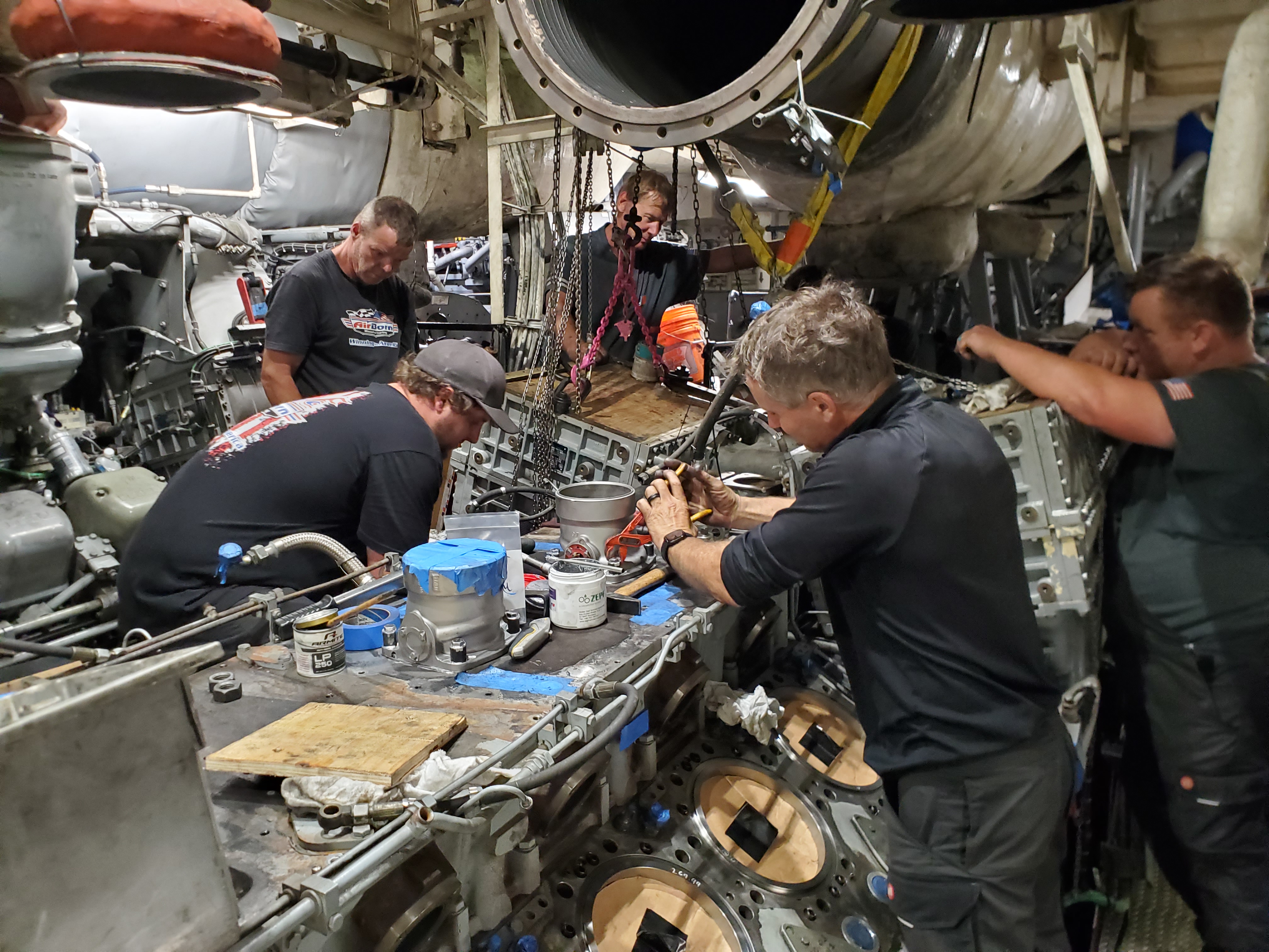 Team members working together around a large industrial engine assembly.