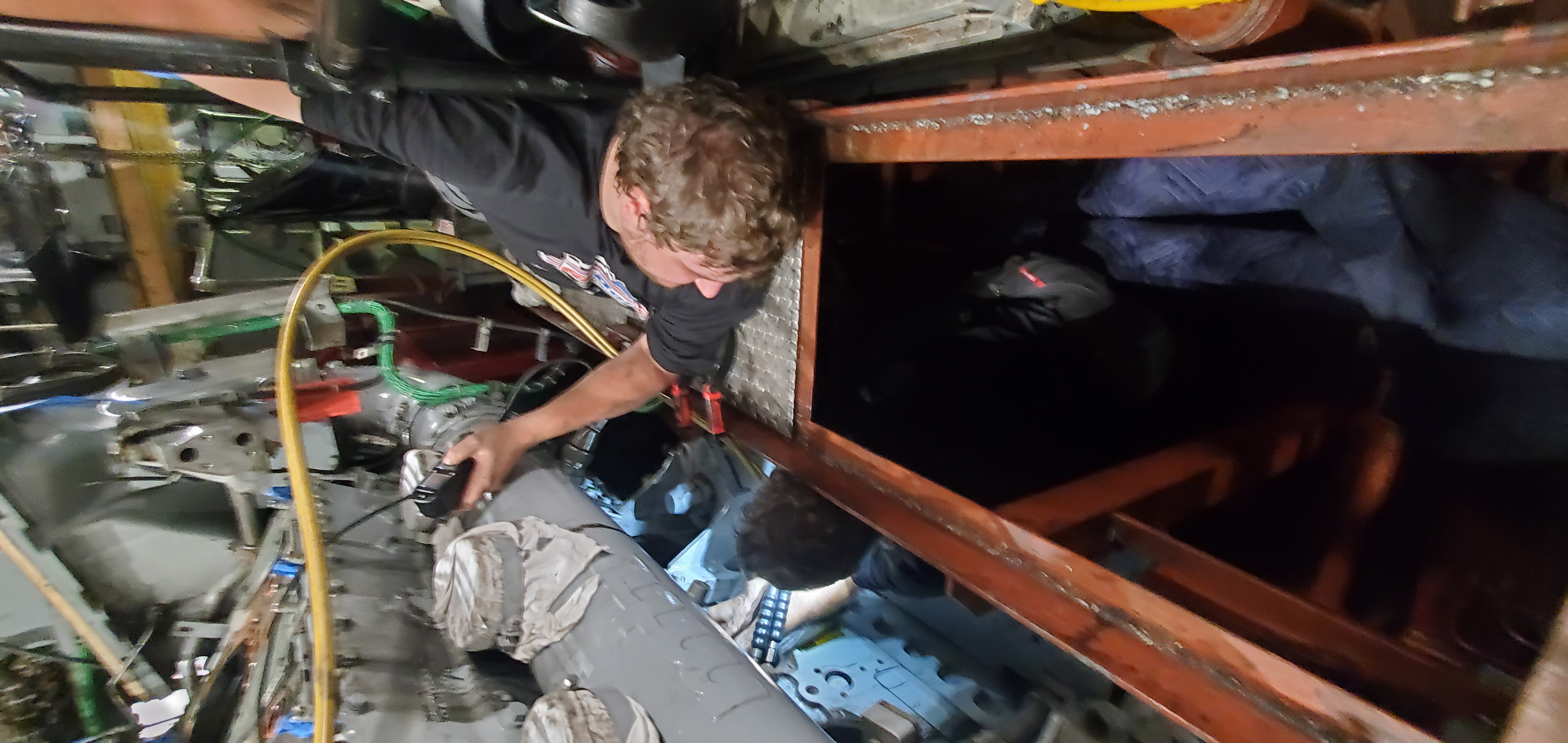 Technician accessing a large industrial engine component in a field service setting.