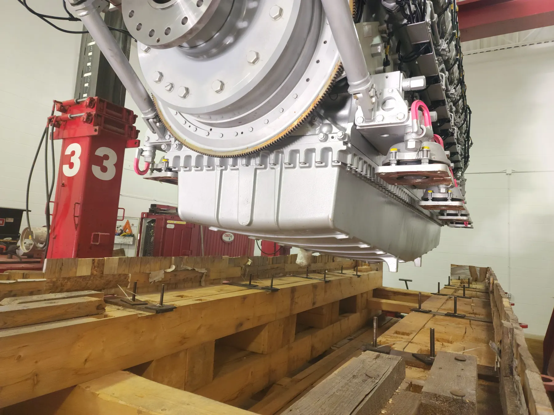 Large engine assembly staged in a shop area with support stands.