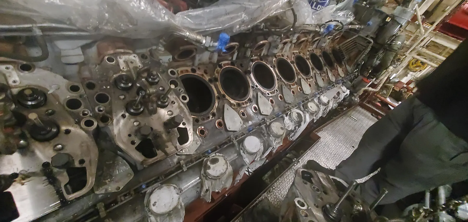 Large industrial engine component with machined openings and internal service details visible.