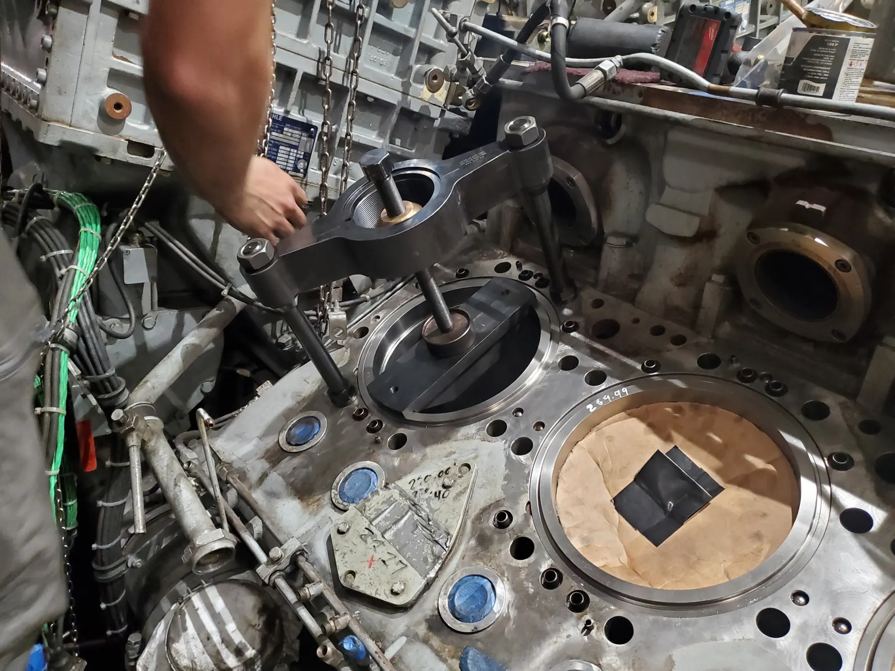 Technician positioning a cover plate on a large engine component.