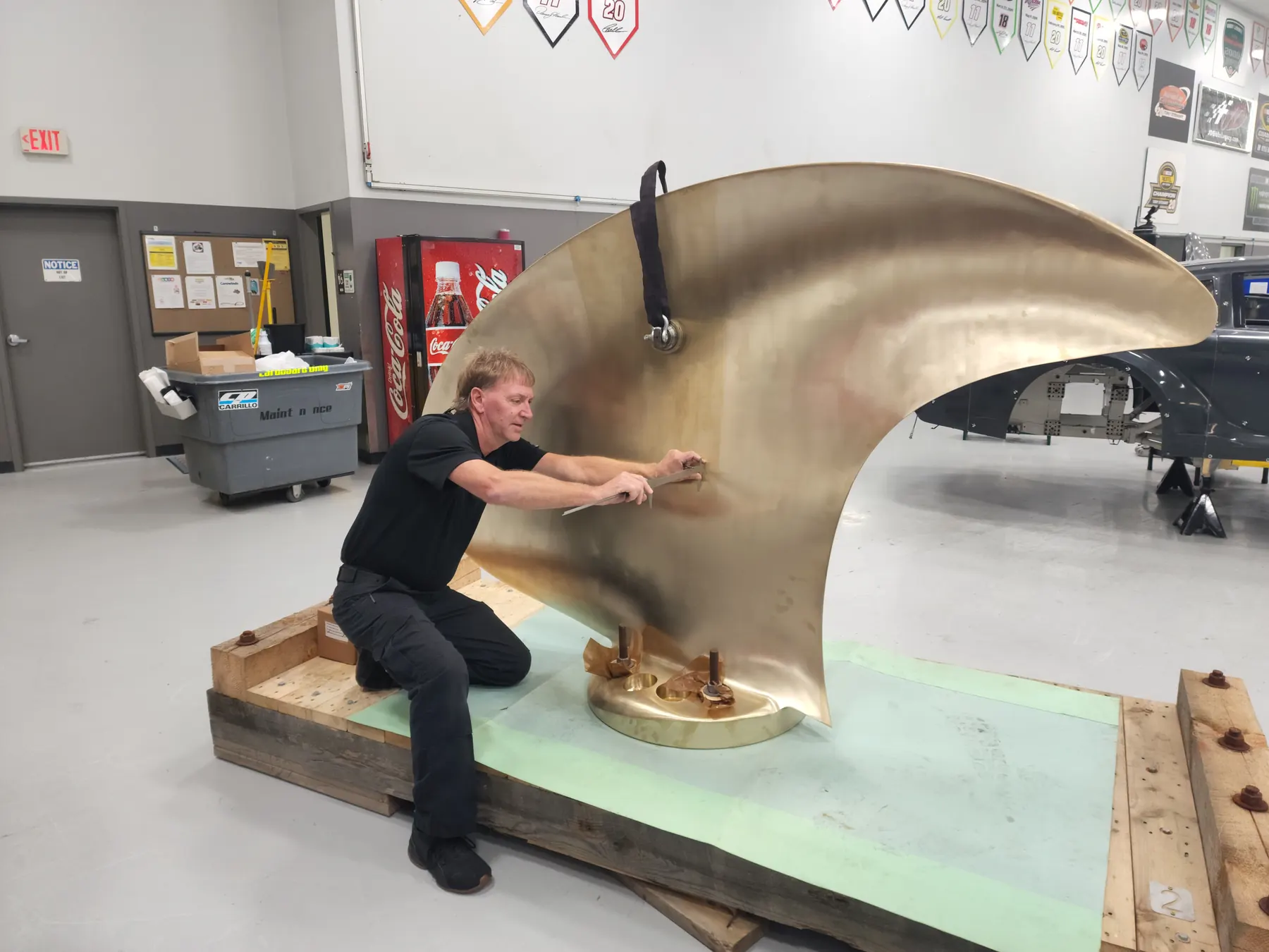 Large formed metal component being reviewed on the shop floor.