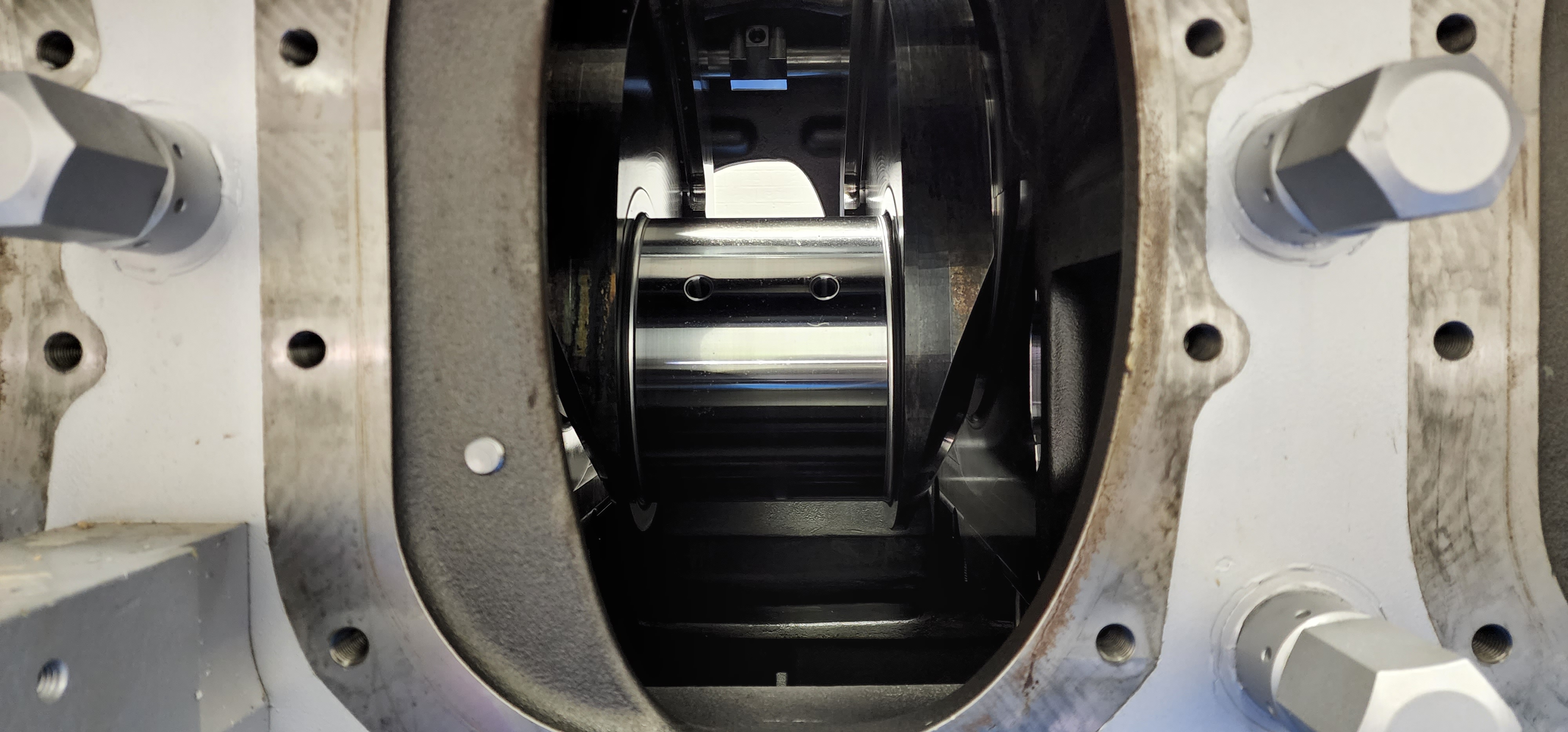 Machined rotor component visible through an inspection opening in a housing.