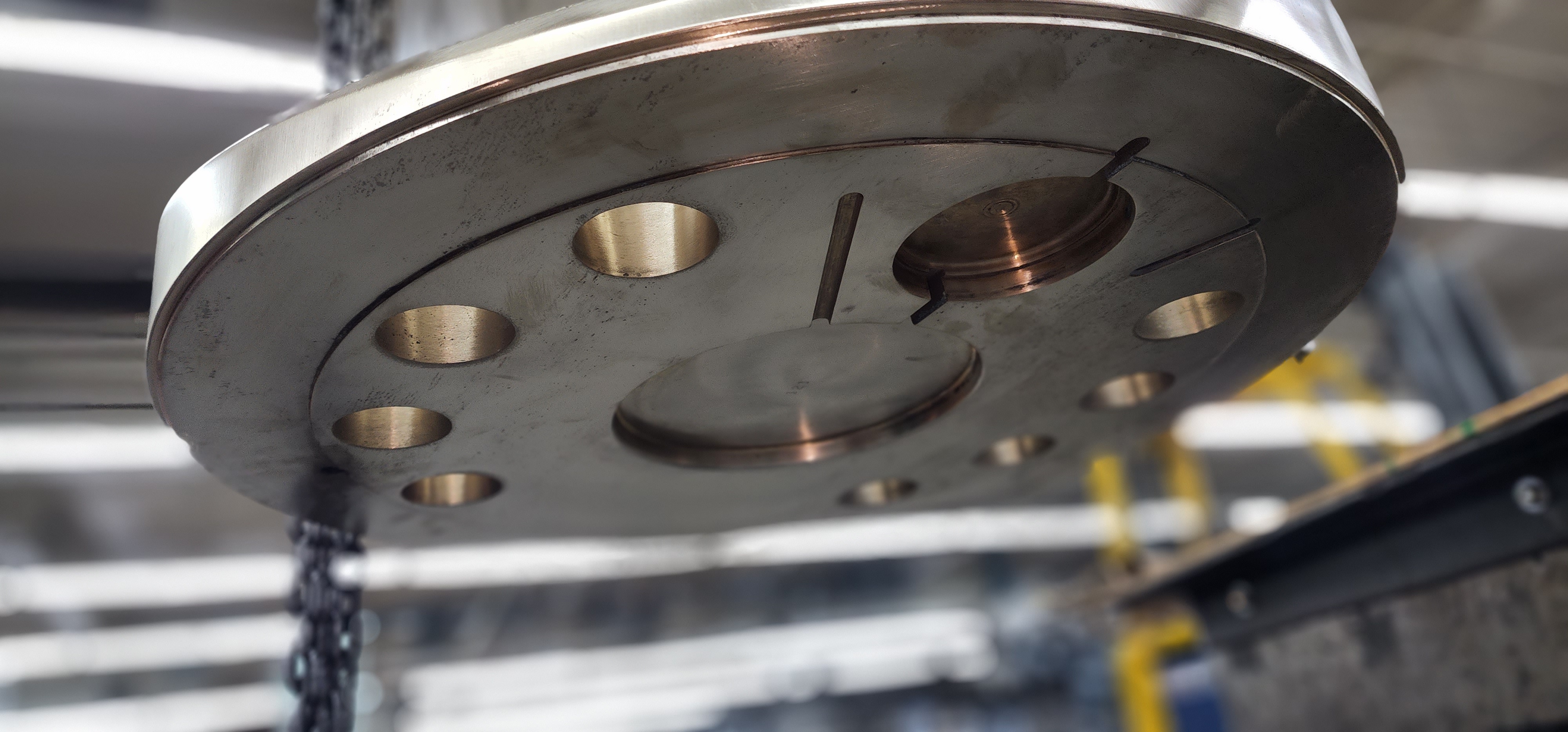 Machined round flange with drilled hole pattern and polished center feature.