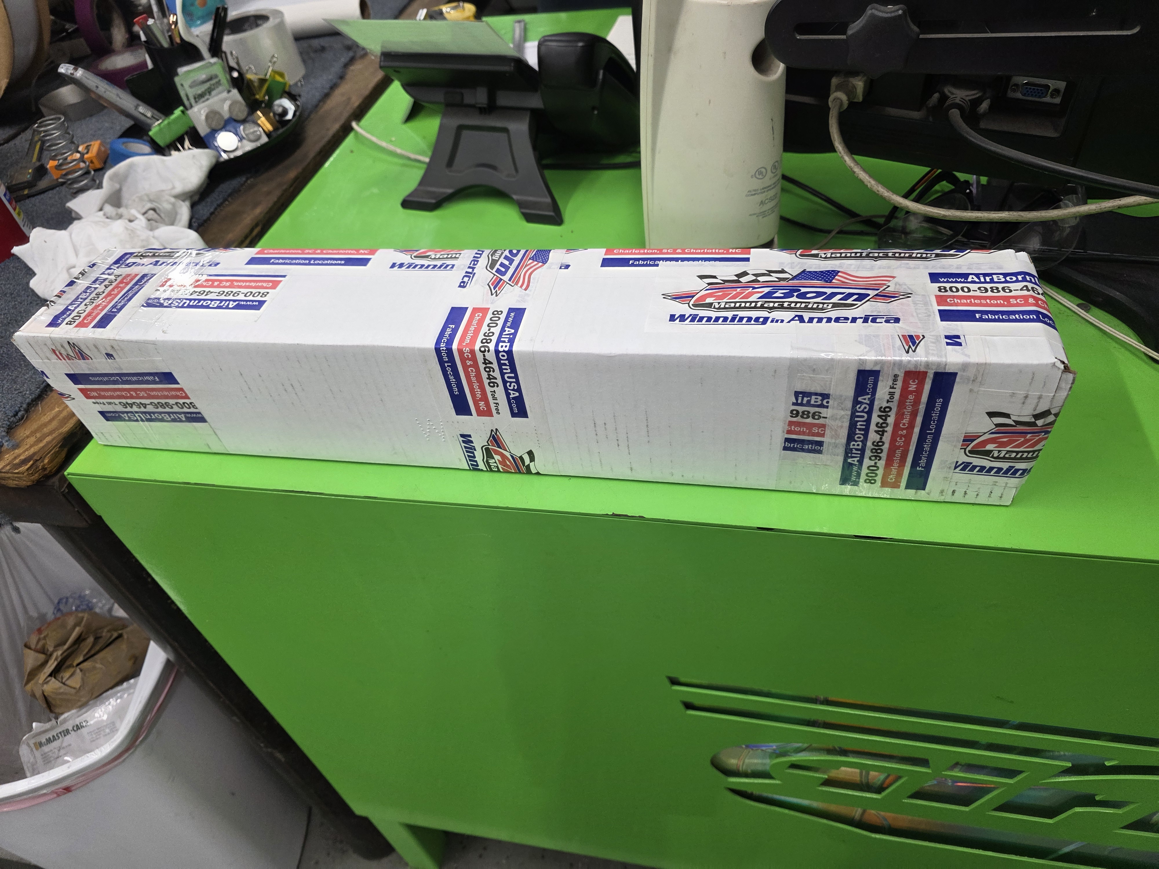 Packaged production materials staged on a shop tool cabinet for assembly work.