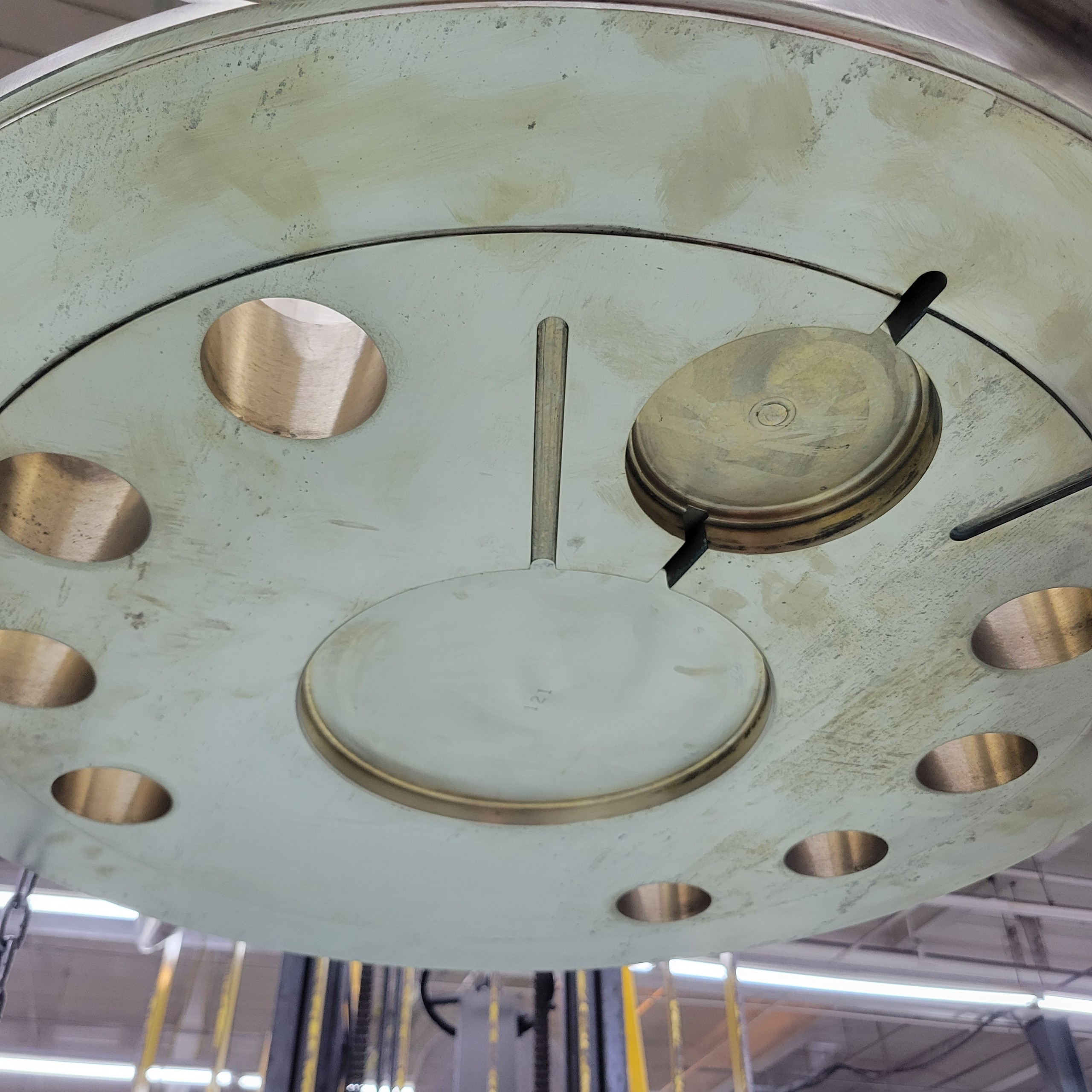 Precision machined round metal flange with drilled hole pattern and center feature.