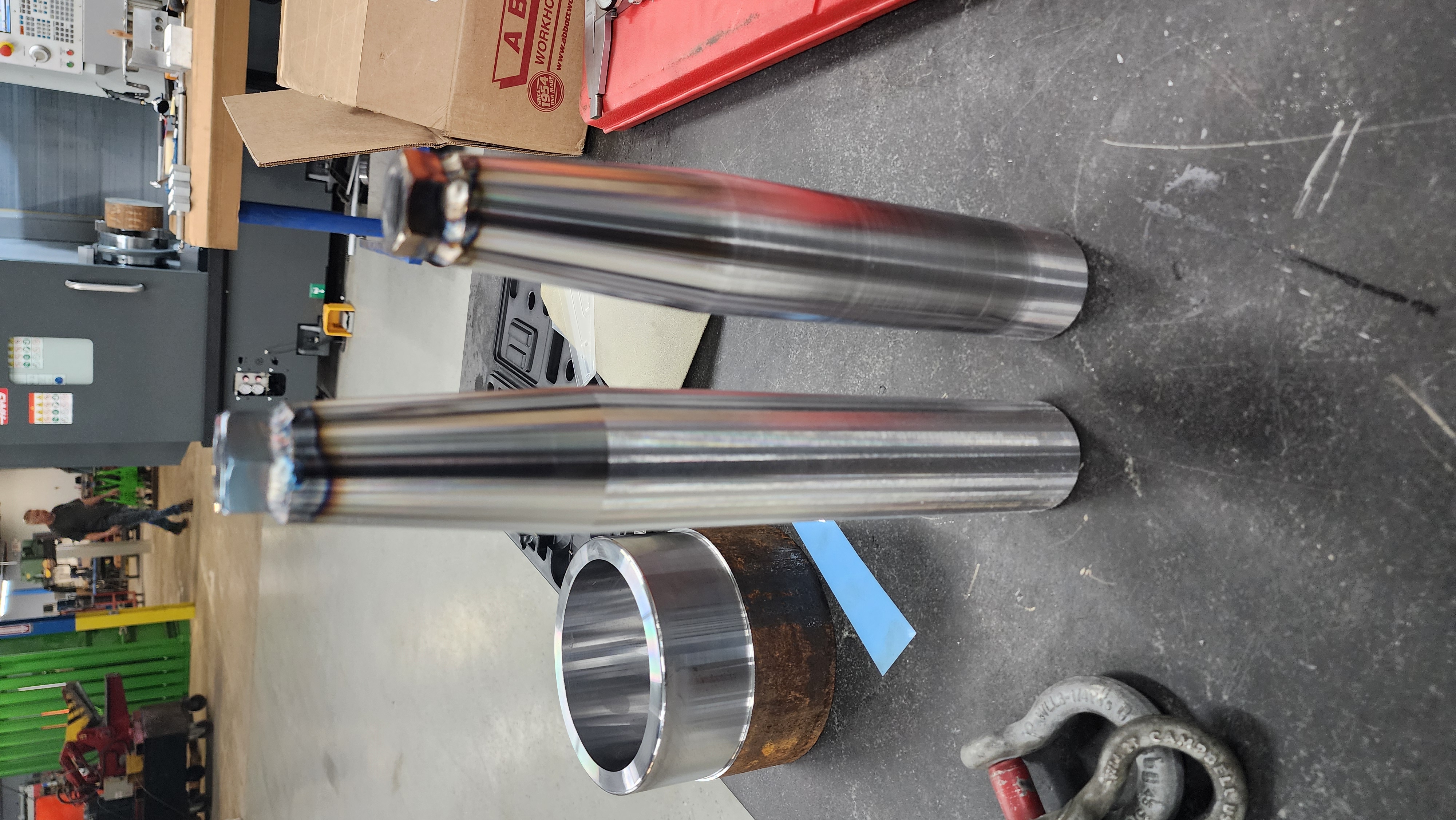 Rolled sheet metal cylinder components prepared for fabrication.