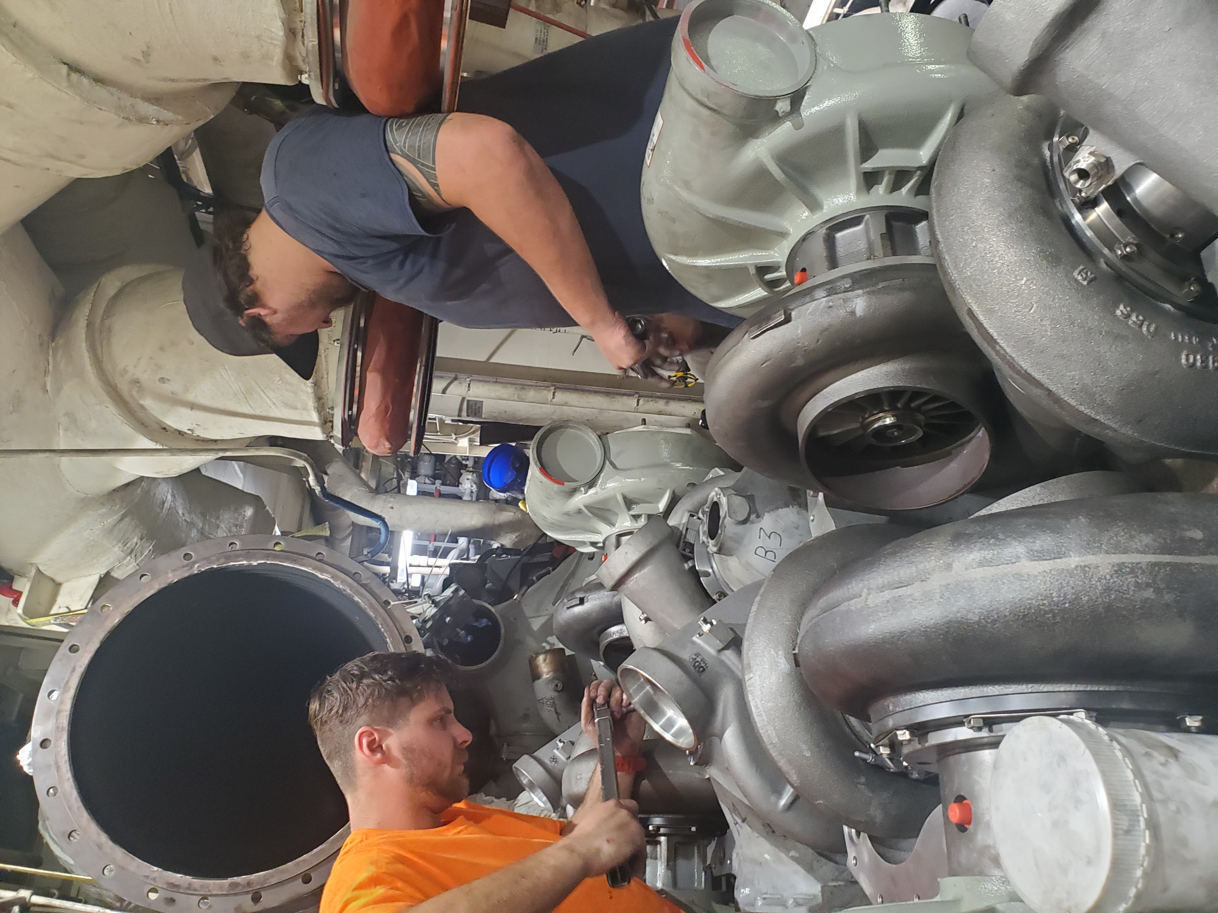 Technician welding or heating a large pipe connection during fabrication repair work.